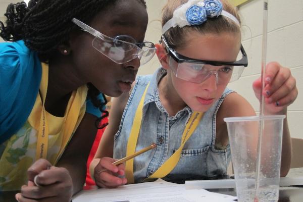 two elementary school girls close up doing a lab experiment
