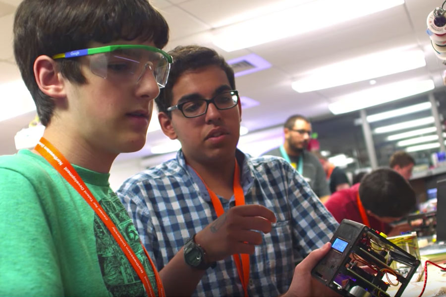 two high school boys in goggles working with electronics