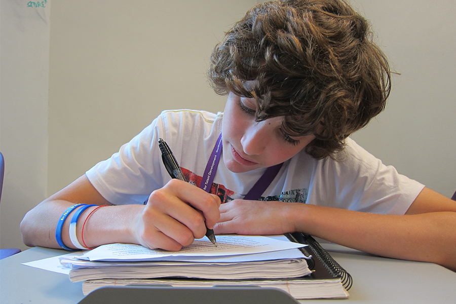 elementary grade student writing at a desk