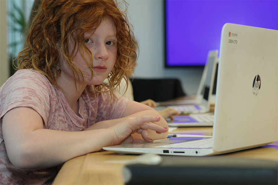 elementary school girl working on laptop