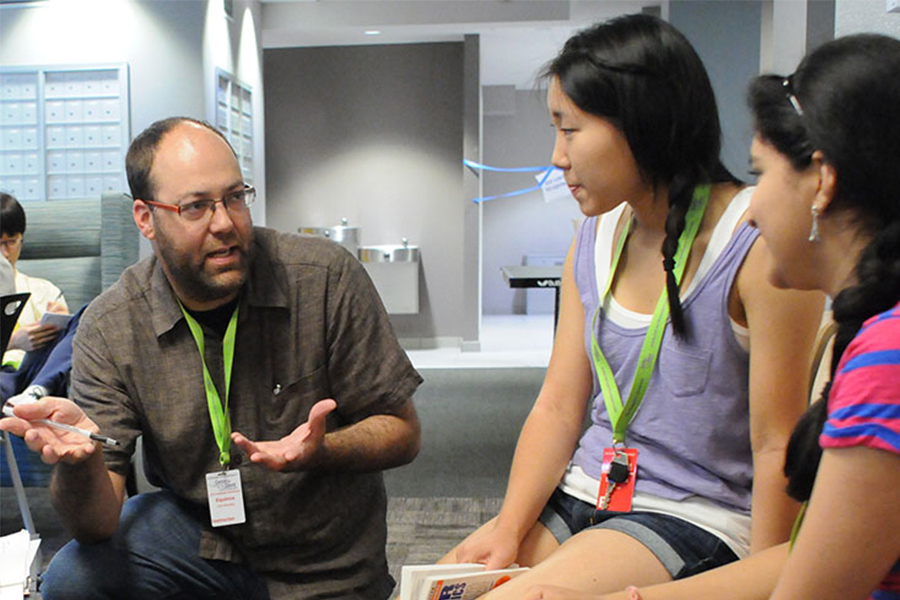 teacher in discussion with two high school students