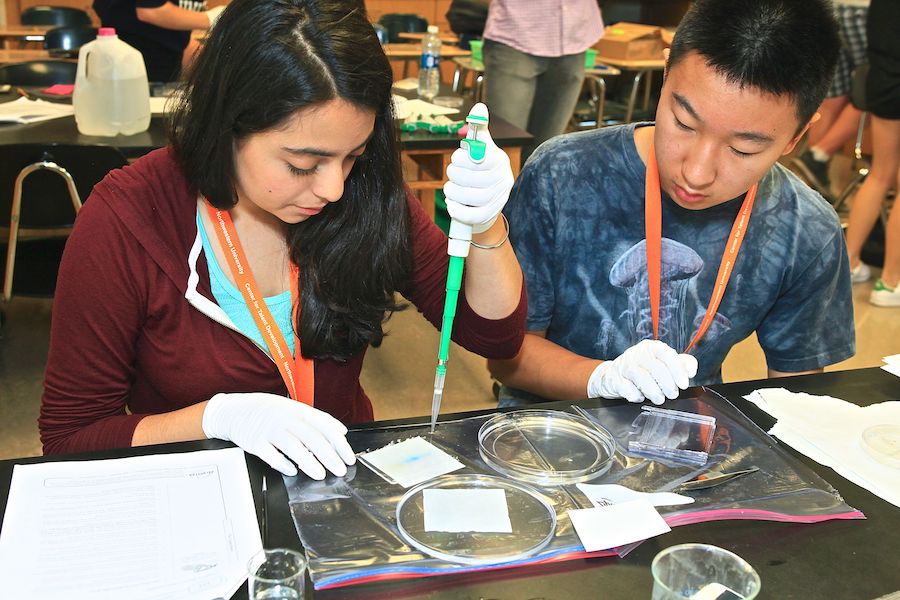 high school boy and girl working with pipettes in lab