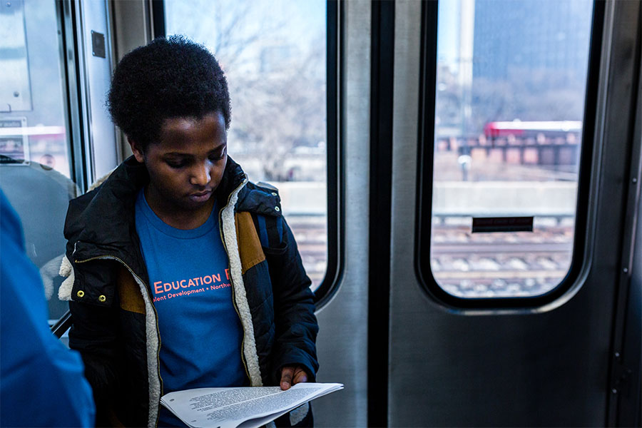 high school girl reading on train