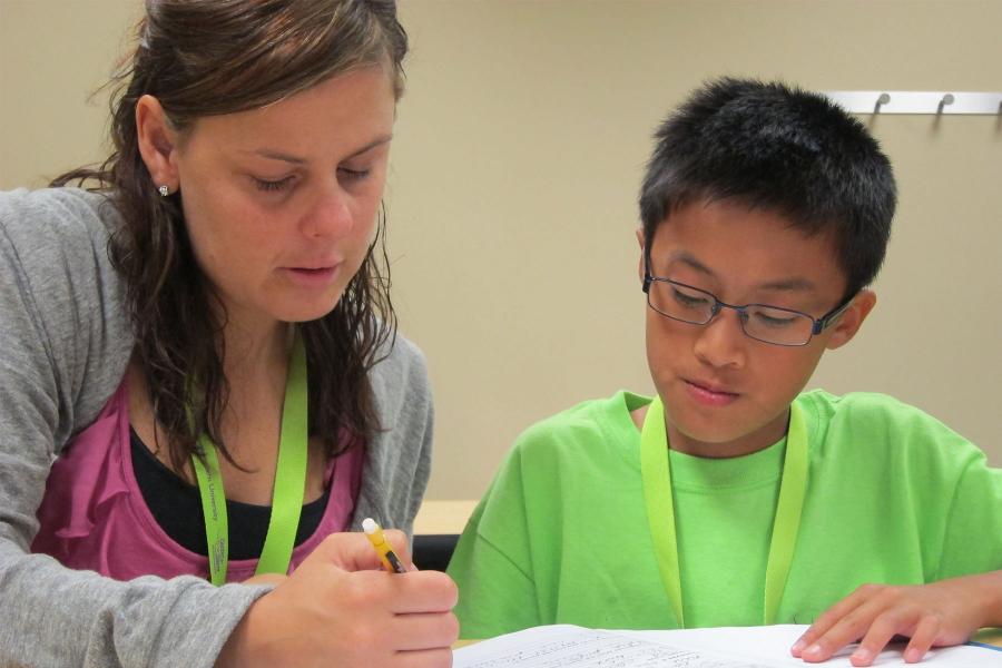 female teacher and elementary school boy working together