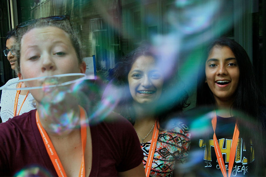 middle school girls outside blowing bubbles