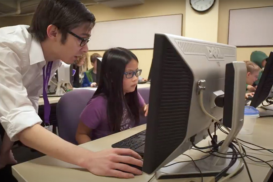 Young girl and teacher using computer