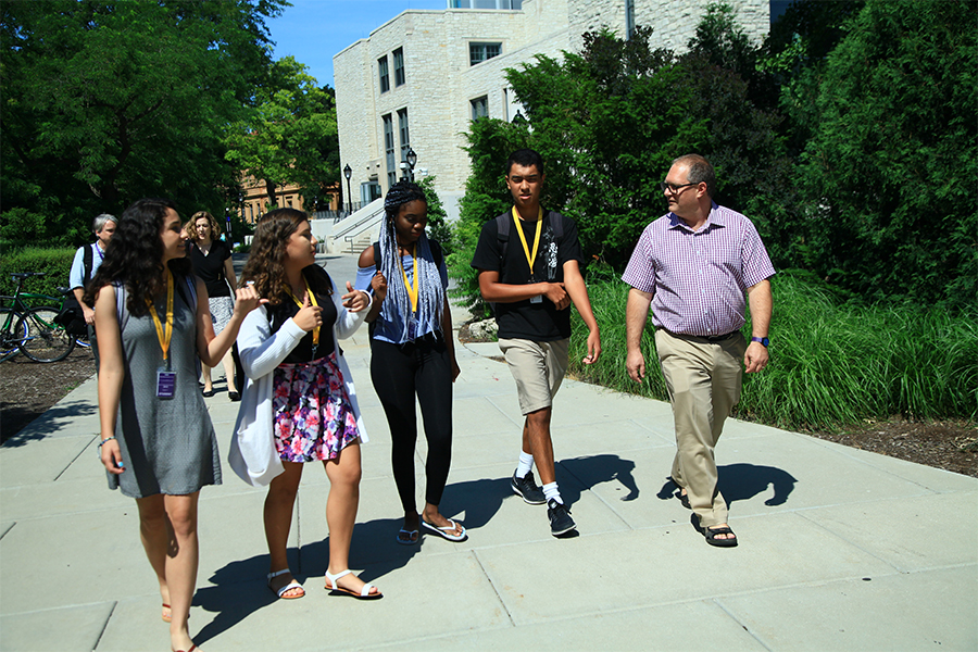 high school students walking on campus with Dean of School of Education and Social Policy