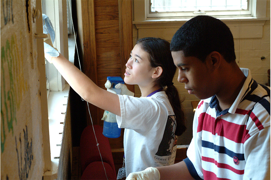 Two students cleaning windows