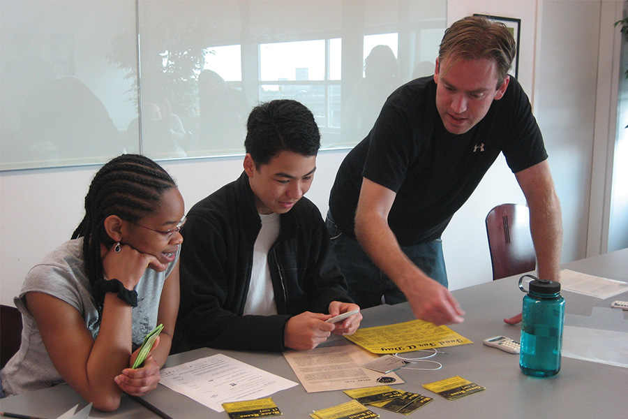 high school boy and girl discussing ideas with adult facilitator