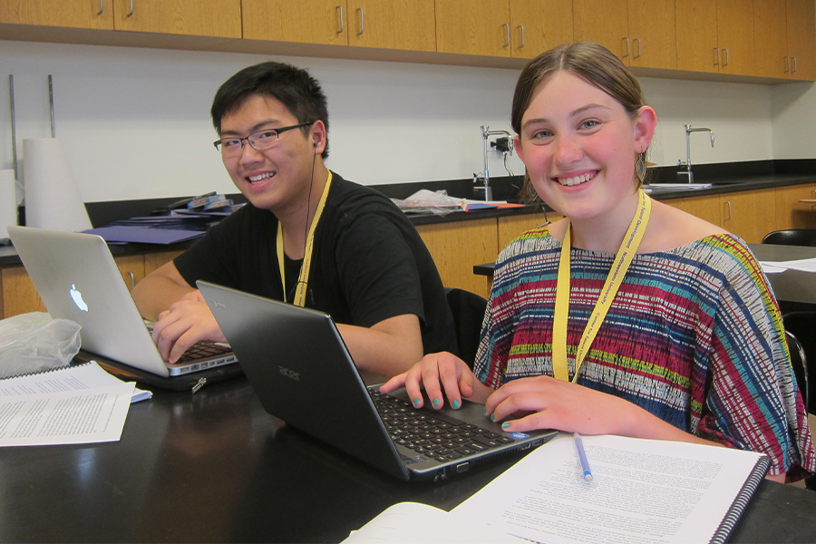 Two high school students working on laptop computers