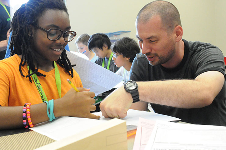 middle school student and teacher working on physics problem