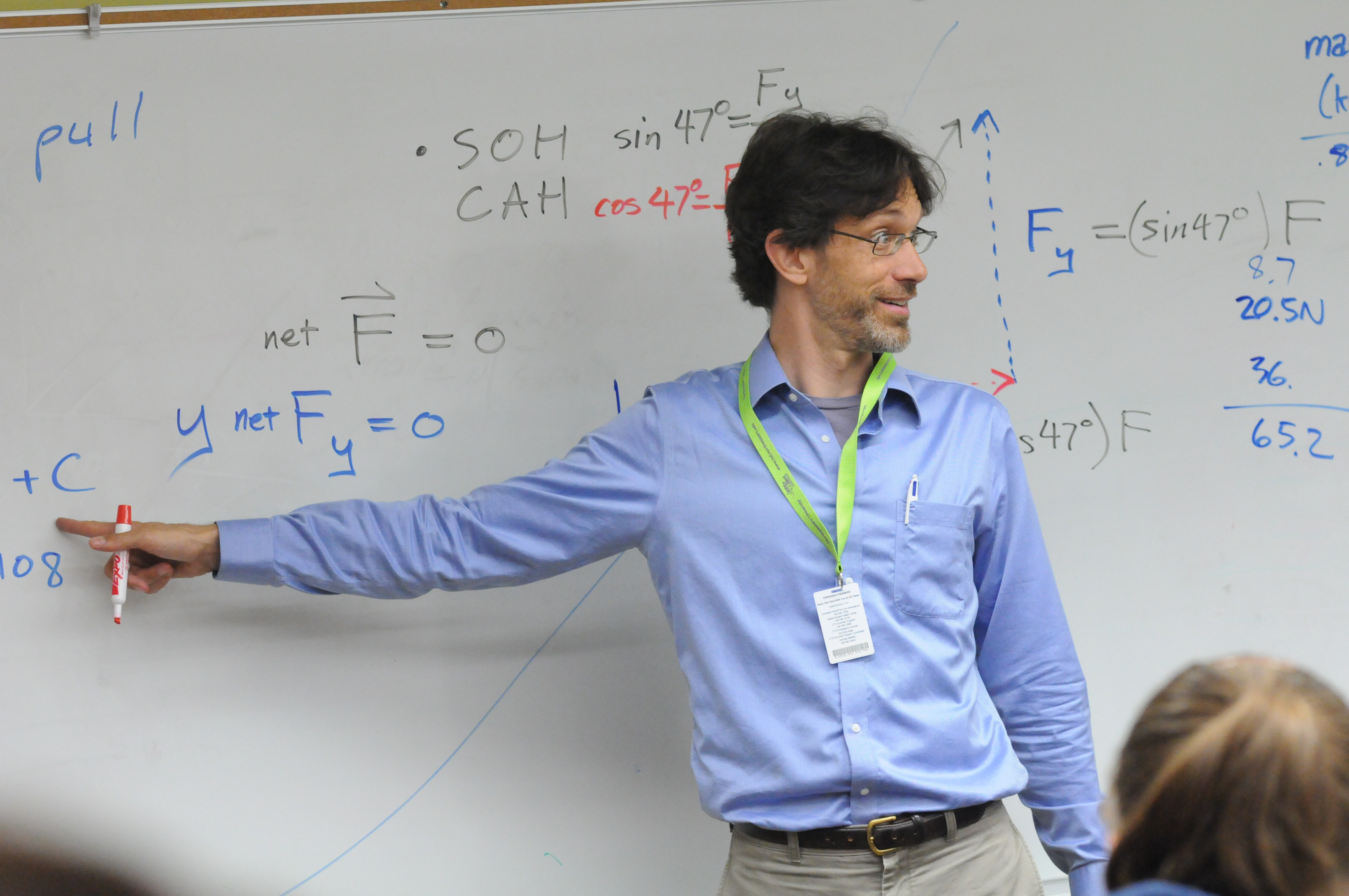 male teacher at blackboard demonstrating math equations