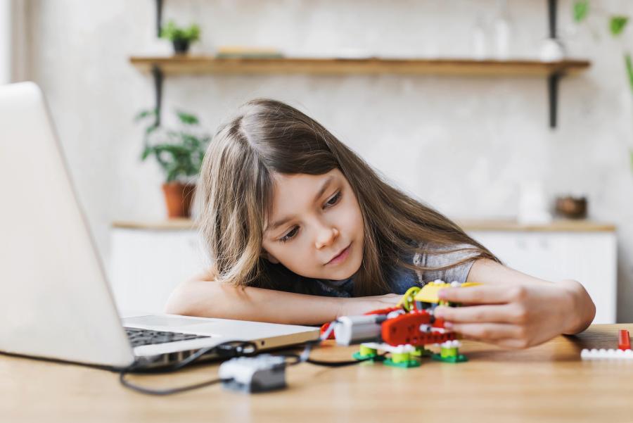 young girl at computer building with legos