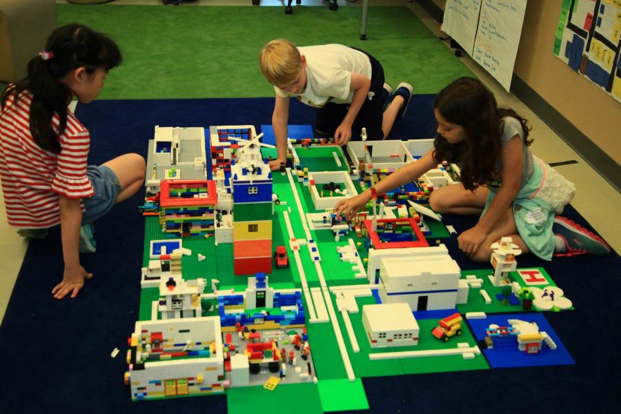 three elementary school students engineering a city with legos