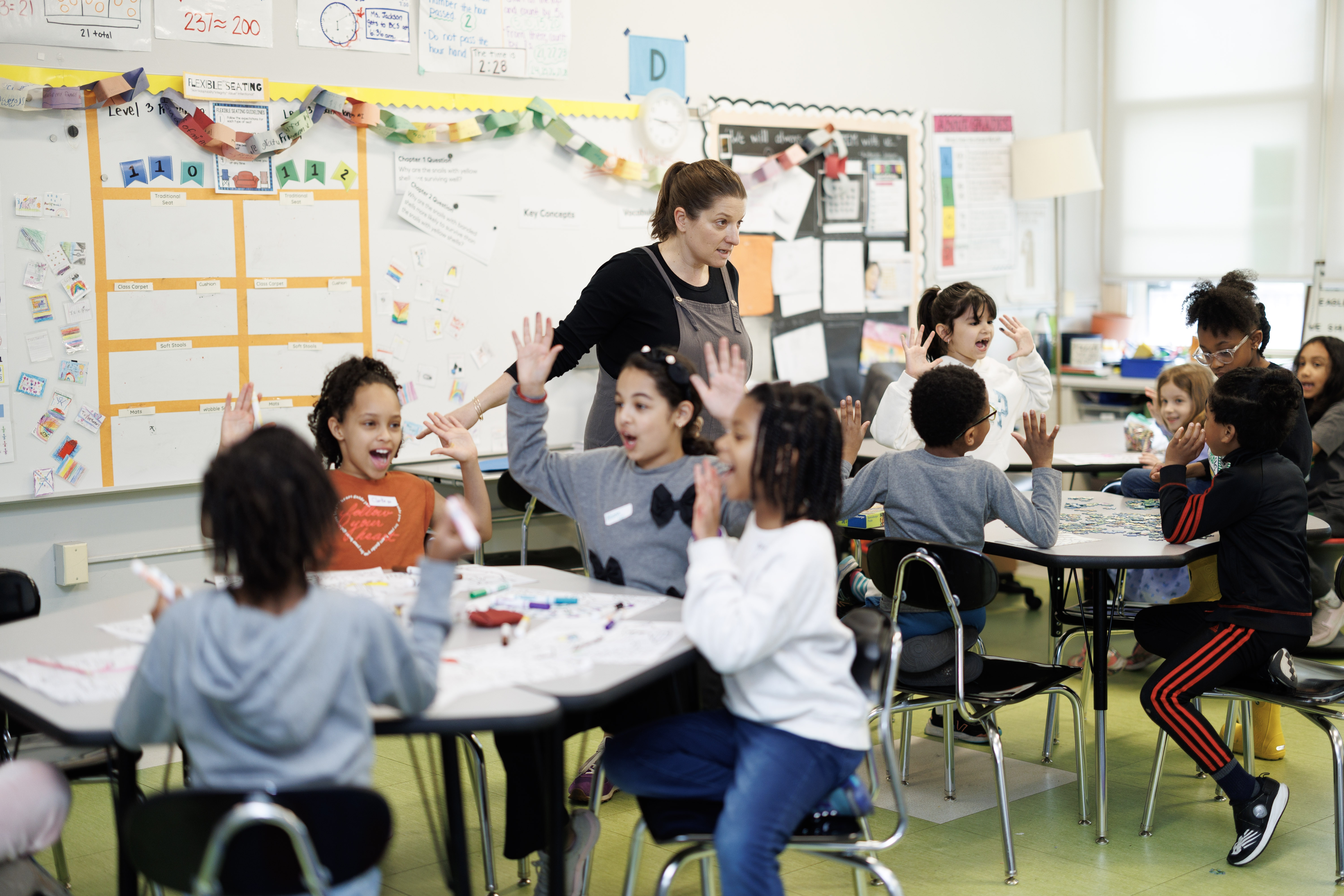 teacher leading a group of elementary school students in an activity