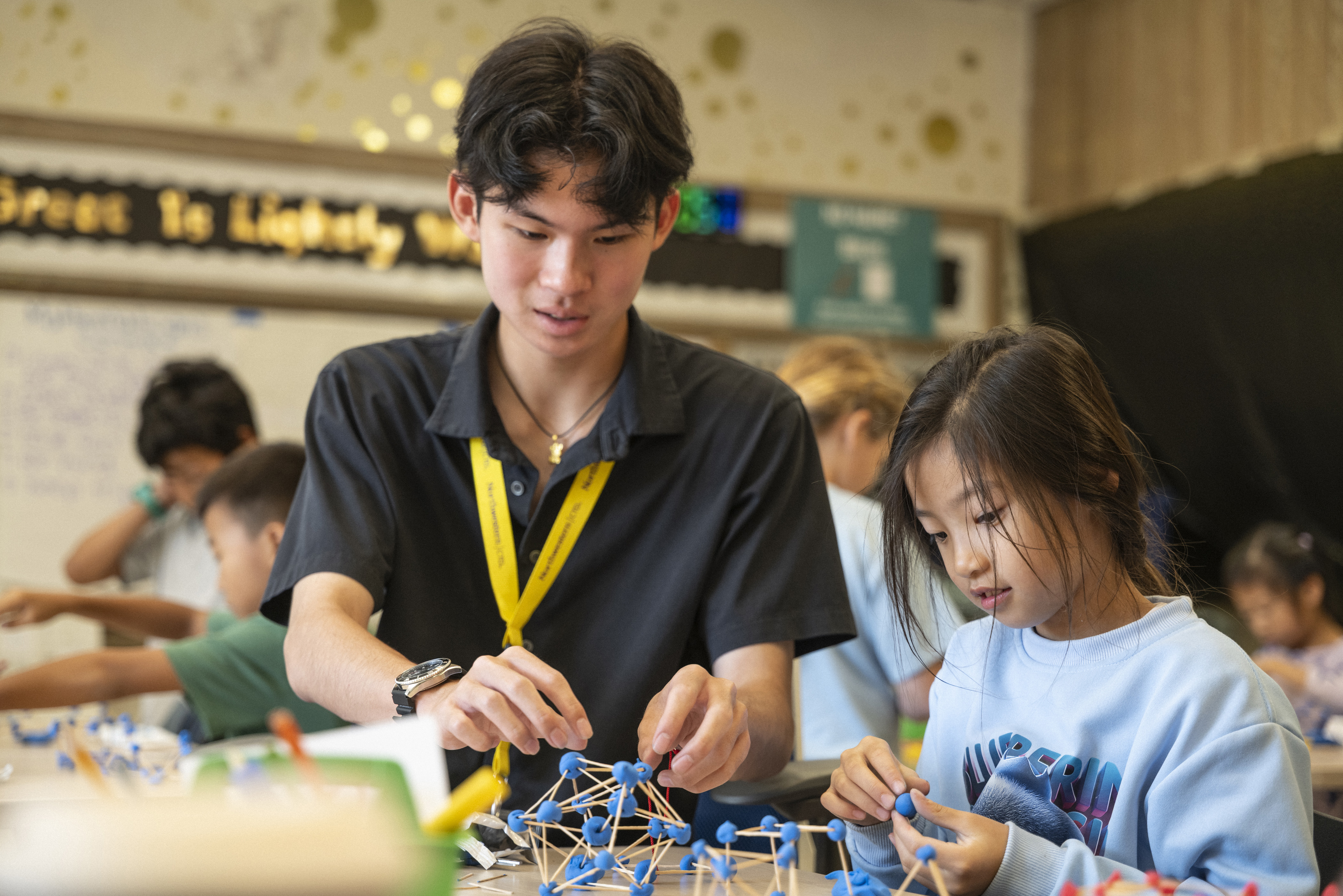 Teacher working with elementary student on building molecules