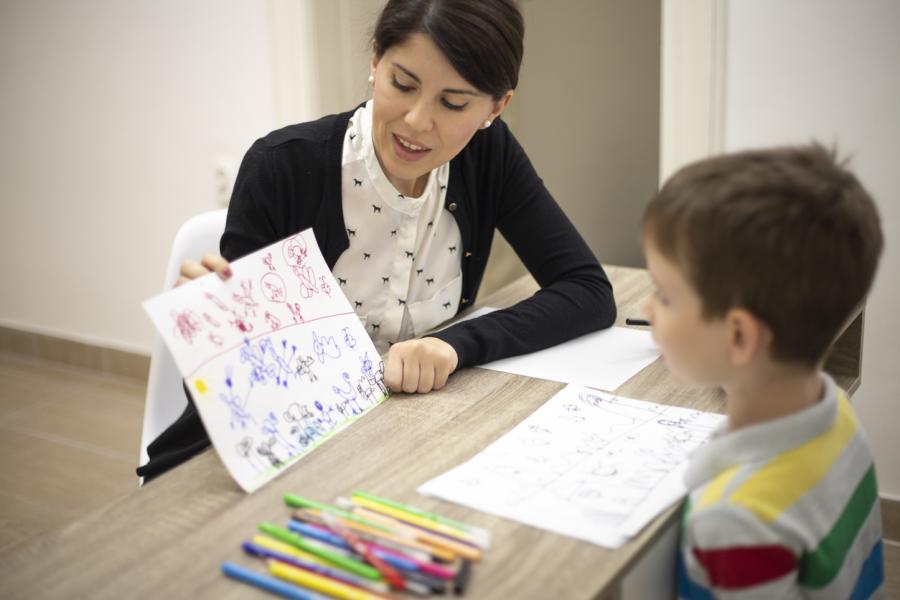 female teacher showing young boy a drawing