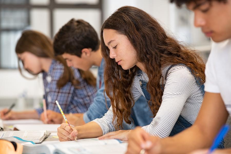 four middle and high school students taking a test