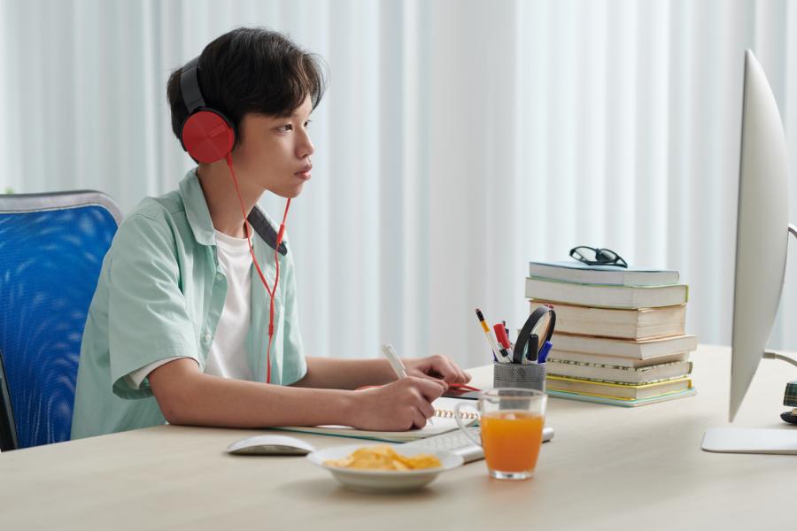 middle school Asian boy taking test on computer