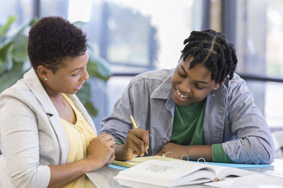 adult with high school student writing a plan