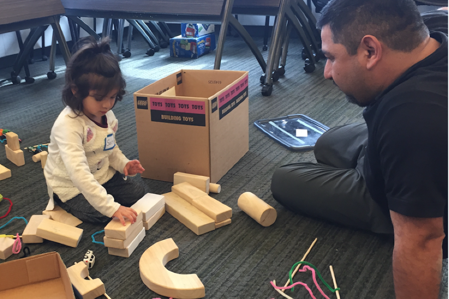 girl with dad building with blocks