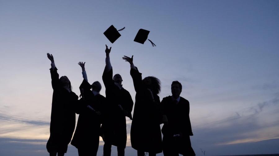 Students throwing graduation caps in the air