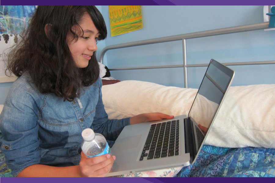 middle school girl at home in her room on computer