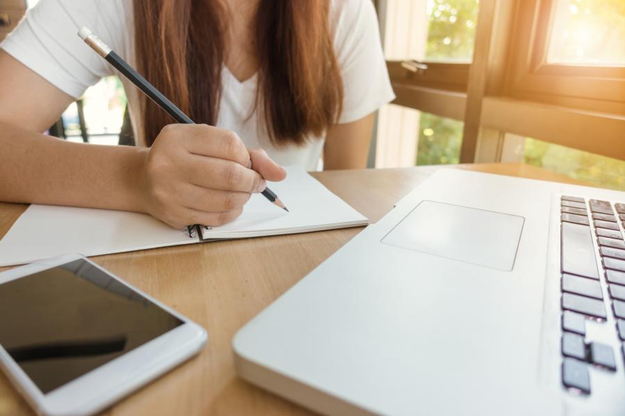 student writing in notebook