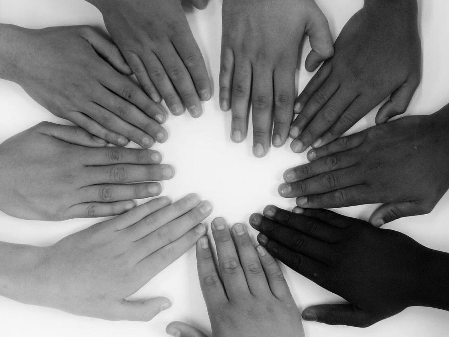 Students holding their hands together in a circle 