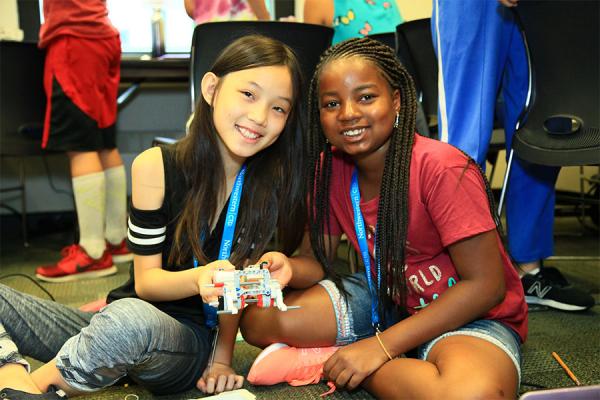 two middle school girls displaying their robot
