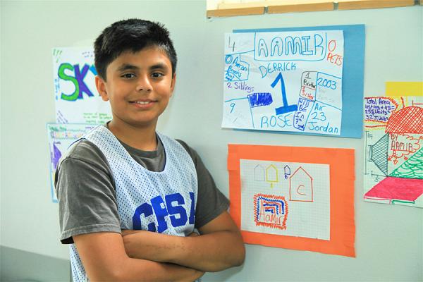 Young boy student in front of wall painting