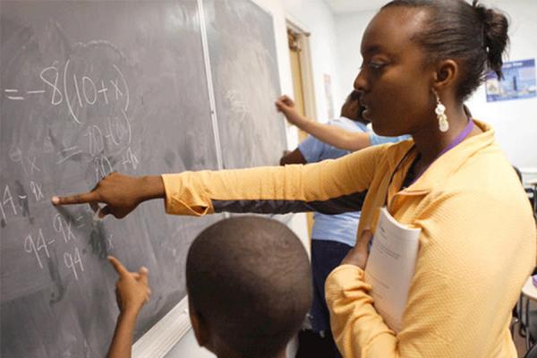 teacher with child working at blackboard