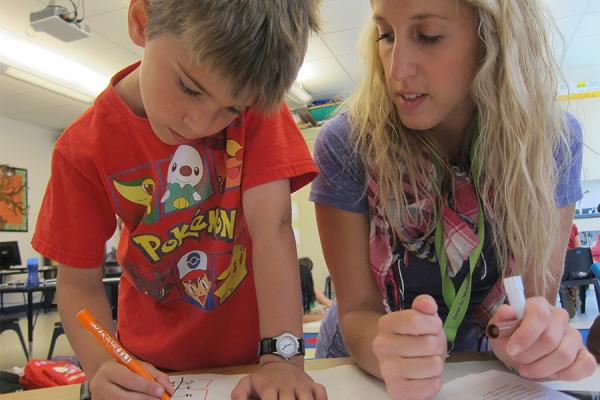 female teacher with young boy in classroom