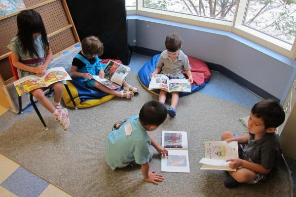 young children reading books on a classroom floor